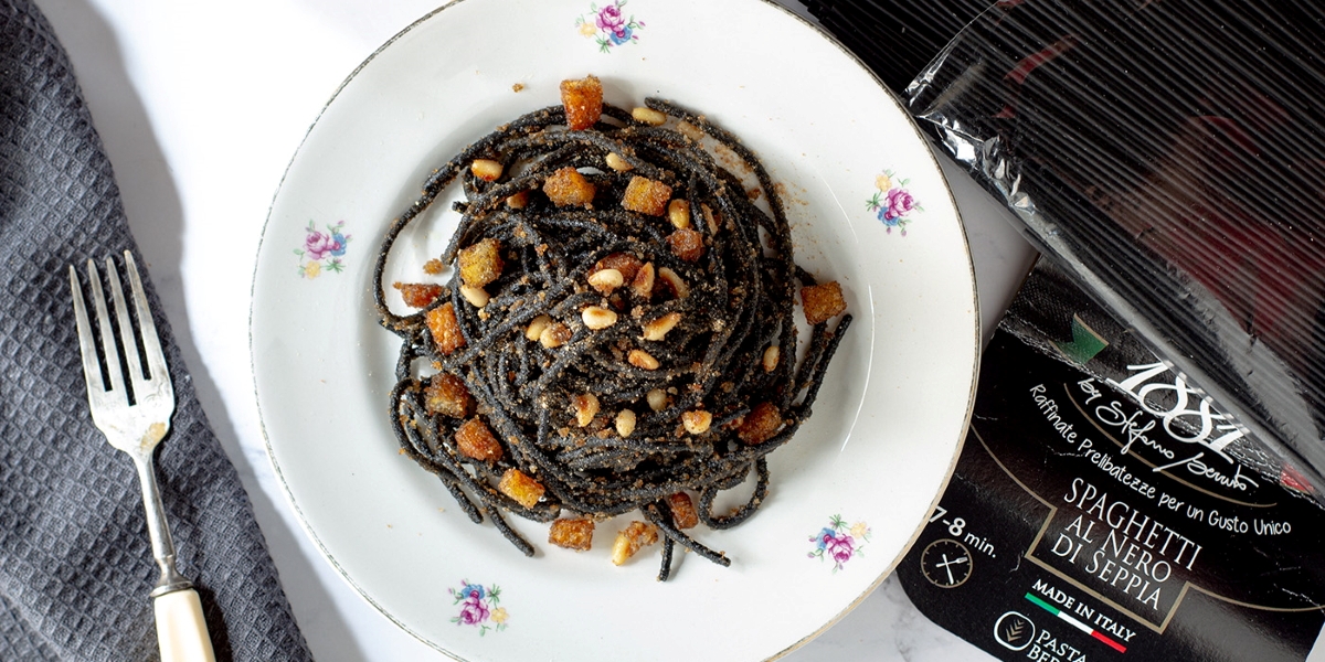 Spaghetti al nero di seppia con acciughe, pinoli e pane tostato